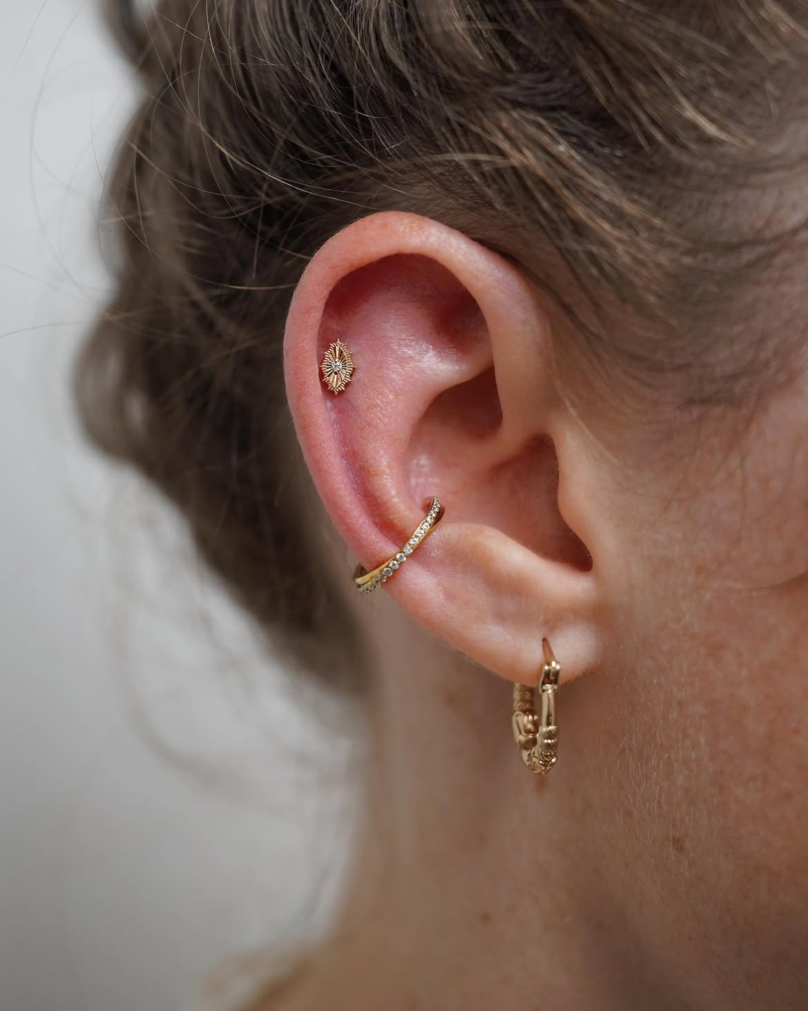 Helix piercing with gold jewelry in Barcelona - Circa Piercing